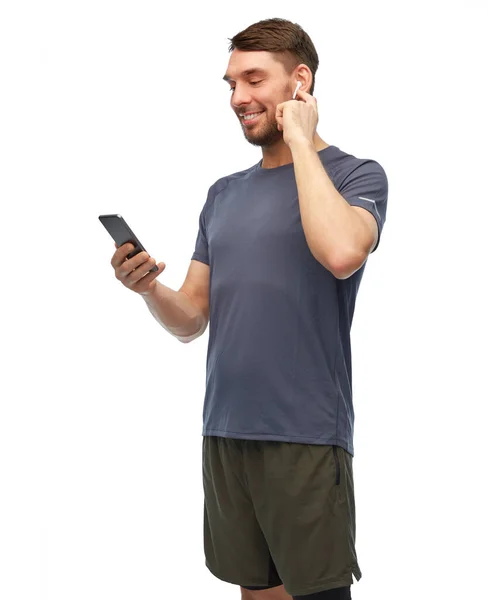 Hombre en ropa deportiva con teléfono y auriculares —  Fotos de Stock