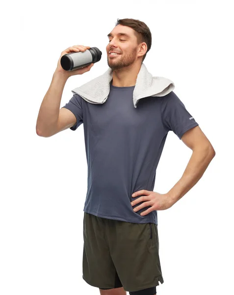 Happy man in sports clothes with bottle and towel — Stock Photo, Image