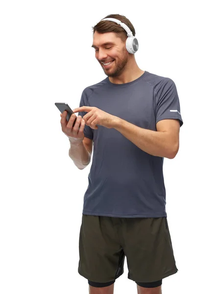 Hombre en ropa deportiva con teléfono y auriculares — Foto de Stock