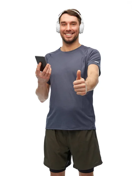 Mężczyzna w ubraniach sportowych z telefonem i słuchawkami — Zdjęcie stockowe