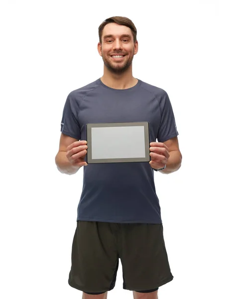 Usmívající se muž ve sportovním oblečení drží tablet ks — Stock fotografie