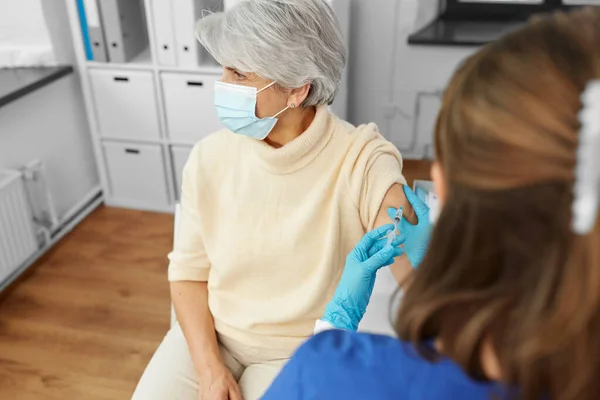 Sjuksköterska med spruta gör injektion till kvinna — Stockfoto