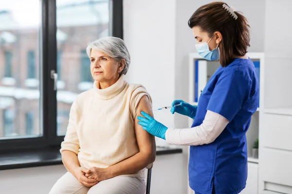 Verpleegkundige met injectiespuit die injectie toedient aan vrouw — Stockfoto