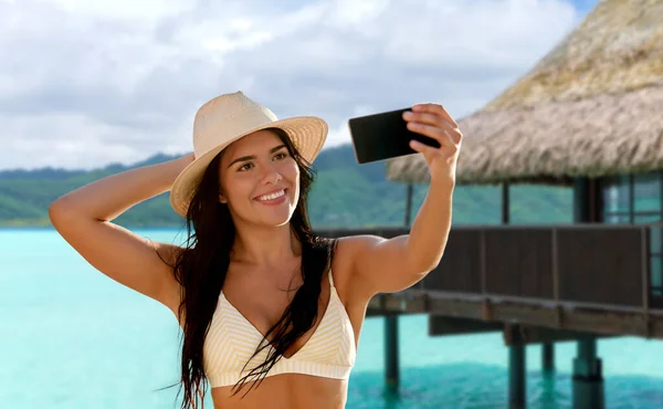 Mujer sonriente en bikini tomando selfie en la playa — Foto de Stock