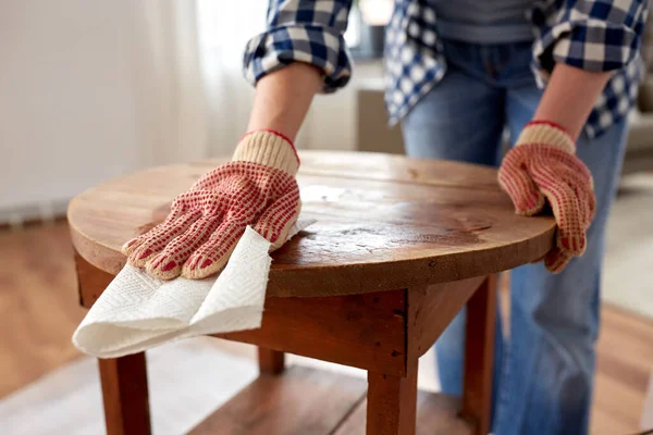 Frau reinigt alte Tischfläche mit Papiertaschentuch — Stockfoto