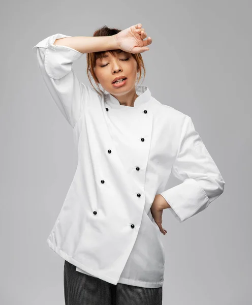 Mujer cocinera cansada en chaqueta blanca —  Fotos de Stock