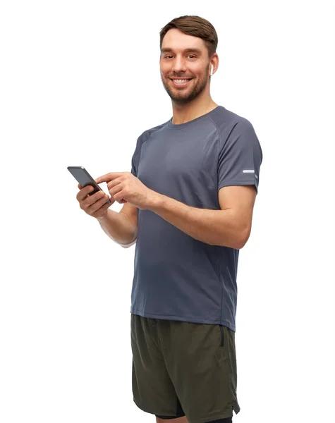 Homem em roupas esportivas com telefone e fones de ouvido — Fotografia de Stock