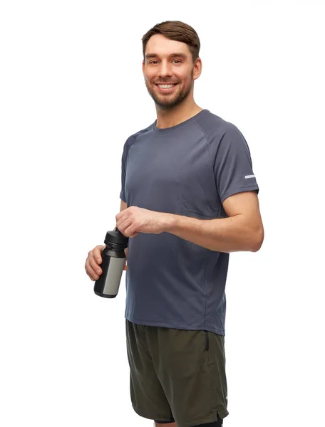 Hombre sonriente en ropa deportiva con botella — Foto de Stock