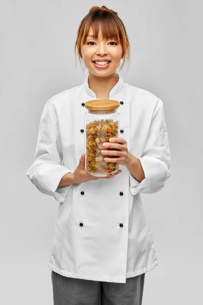 Chef sonriente sosteniendo tarro con pasta Imagen de archivo