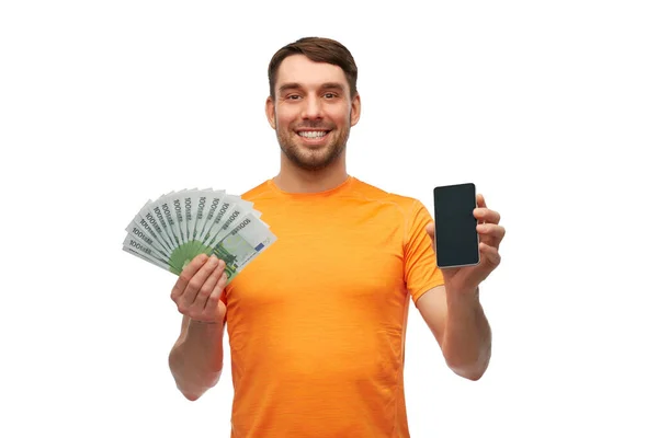Hombre feliz sosteniendo teléfono inteligente y dinero — Foto de Stock