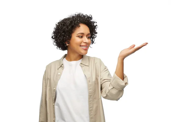 Gelukkig glimlachende vrouw houden iets op haar hand — Stockfoto