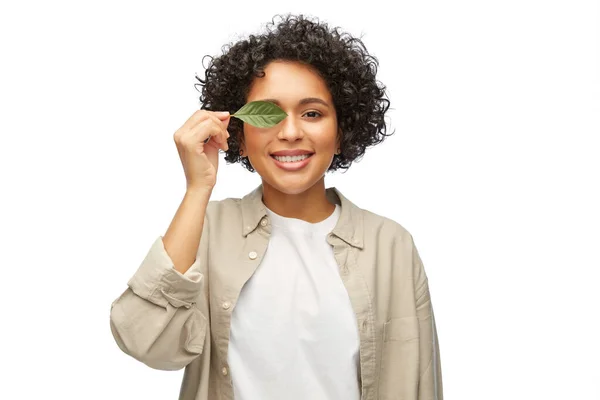 Χαμογελαστή γυναίκα που κρατάει πράσινο φύλλο — Φωτογραφία Αρχείου
