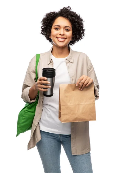 Szczęśliwa kobieta z termofiliżanką, papierową torbą i shopperem — Zdjęcie stockowe