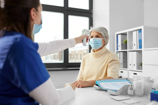 Médecin avec thermomètre et femme à l'hôpital — Photo