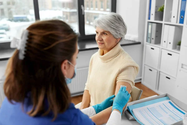Läkare förbereda äldre kvinna för vaccination — Stockfoto