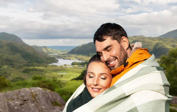 Sıcak battaniyeli mutlu çift İrlanda manzarası üzerinde — Stok fotoğraf