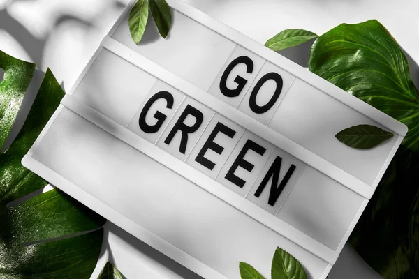 Caja de luz con ir verde palabras y hojas — Foto de Stock