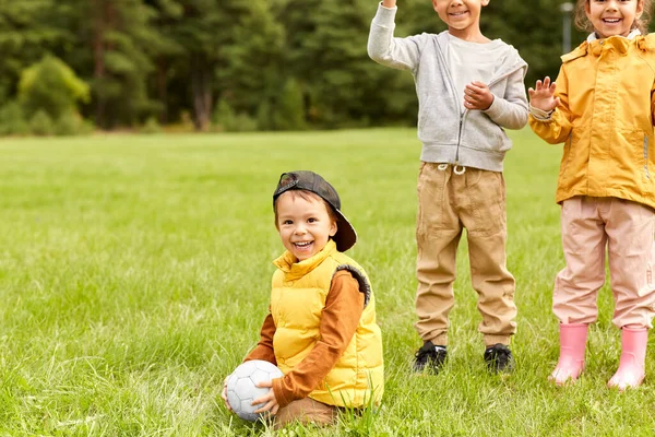Ευτυχισμένα παιδιά με μπάλα ποδοσφαίρου στο πάρκο — Φωτογραφία Αρχείου