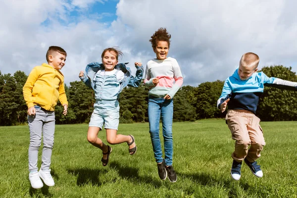 Niños felices saltando y divirtiéndose en el parque —  Fotos de Stock