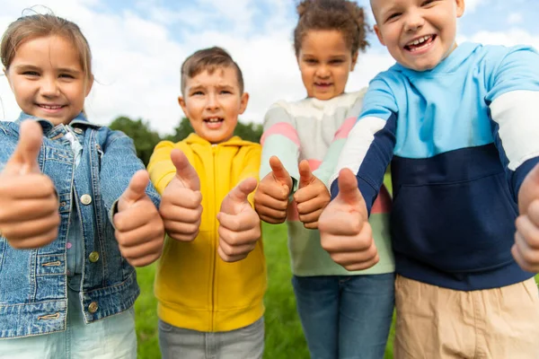 Glückliche Kinder zeigen Daumen hoch im Park — Stockfoto