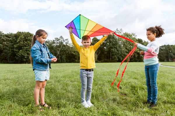 Happy kids with kite playing at park — Stock Photo, Image