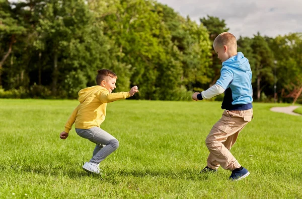 Two happy boys playing tag game at park — Stock Photo, Image