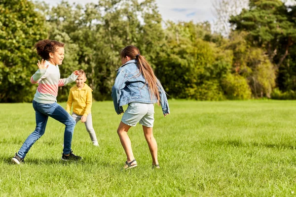 Glada barn som leker och springer i parken — Stockfoto