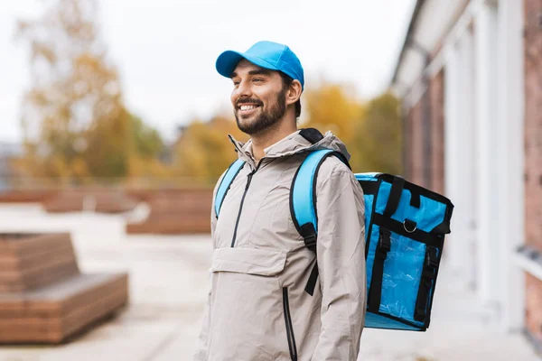 Happy delivery man with thermal bag in city — Stock Photo, Image