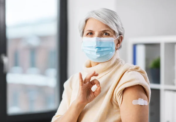 Mujer vacunada con máscara con parche médico en el brazo — Foto de Stock