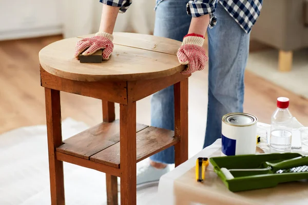 Woman sanding old round wooden table with sponge — Stock Photo, Image