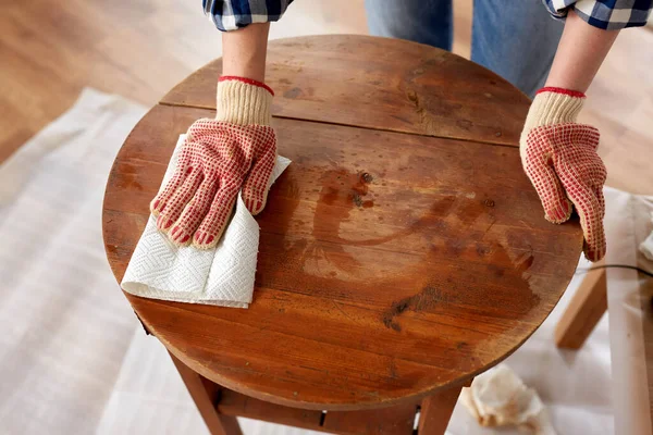 Frau reinigt alte Tischfläche mit Papiertaschentuch — Stockfoto