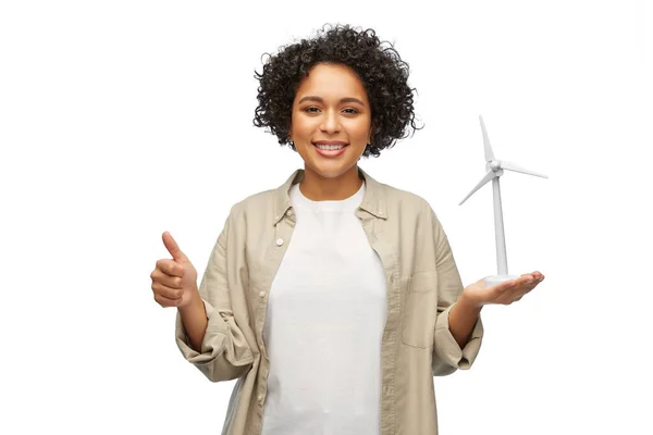 Жінка тримає іграшкову вітрову турбіну, показуючи великі пальці вгору — стокове фото