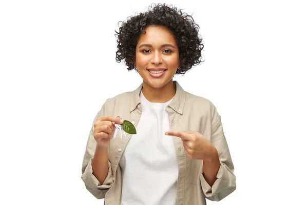 Kvinna som håller hus nycklar med gröna löv — Stockfoto