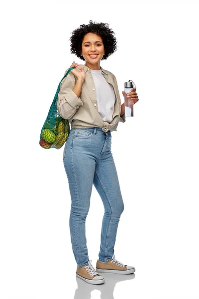 Happy woman with water in glass bottle and shopper — Stock Photo, Image