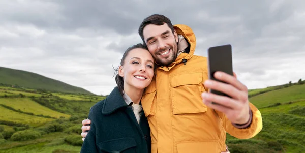 Para biorąc selfie ze smartfonem w Irlandii — Zdjęcie stockowe