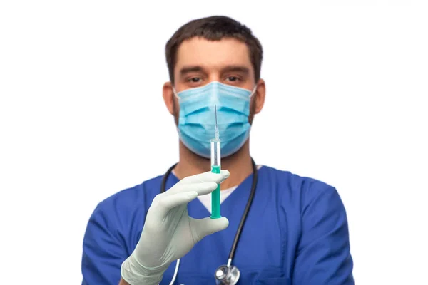 Médecin masculin masqué et gants avec seringue — Photo