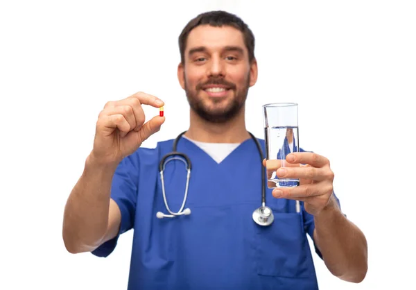 Щасливий лікар або медсестра чоловічої статі з ліками та водою — стокове фото