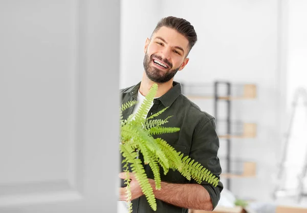 Hombre feliz con flor de helecho y mudarse a un nuevo hogar —  Fotos de Stock