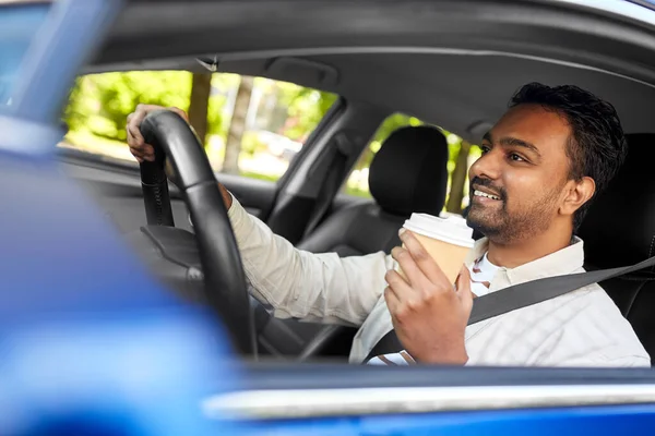 Glücklicher indischer Mann oder Fahrer mit Kaffee fahrendem Auto — Stockfoto