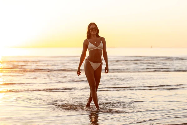 Mulher sorridente feliz em biquíni na praia sobre o pôr do sol — Fotografia de Stock