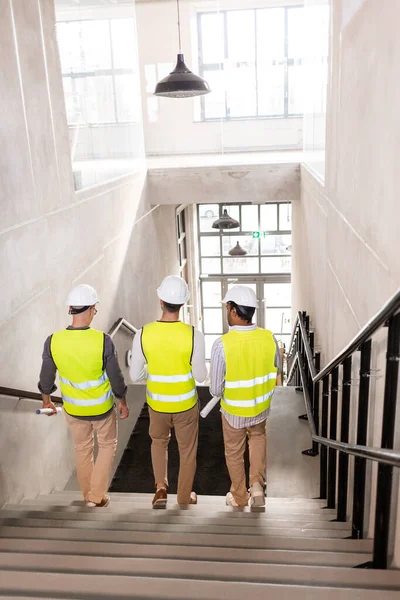 Architekti v helmách kráčející po schodech do kanceláře — Stock fotografie