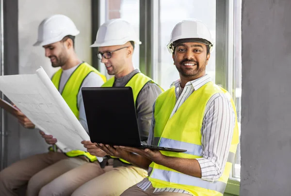 Arquitectos masculinos en cascos trabajando en la oficina — Foto de Stock