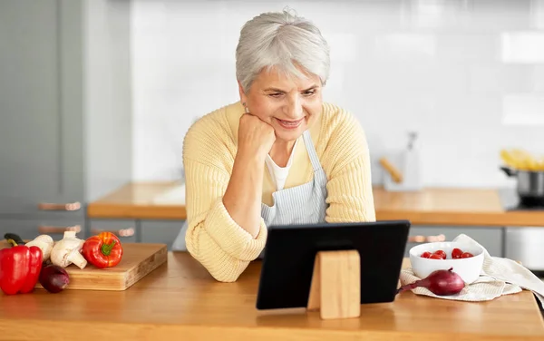 Donna felice con tablet pc in cucina a casa — Foto Stock