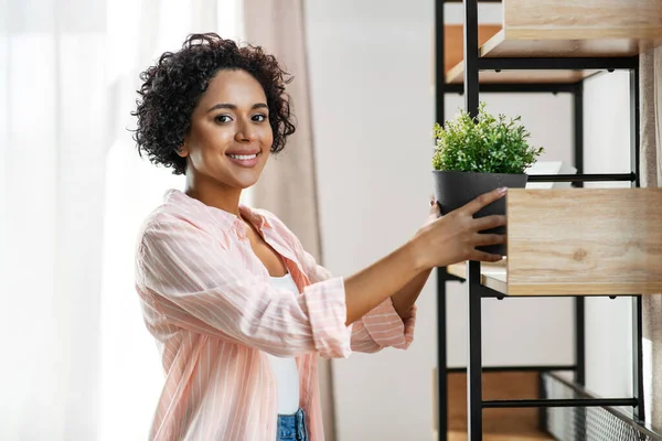 Woman decorating home with flower or houseplant — Stock Photo, Image