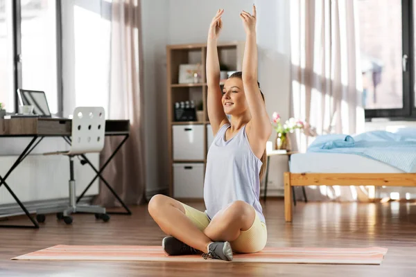 Szczęśliwy nastolatek dziewczyna ćwiczenia na jogi mata w domu — Zdjęcie stockowe