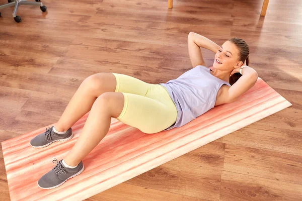 Счастливая девочка-подросток тренируется на коврике для йоги дома — стоковое фото