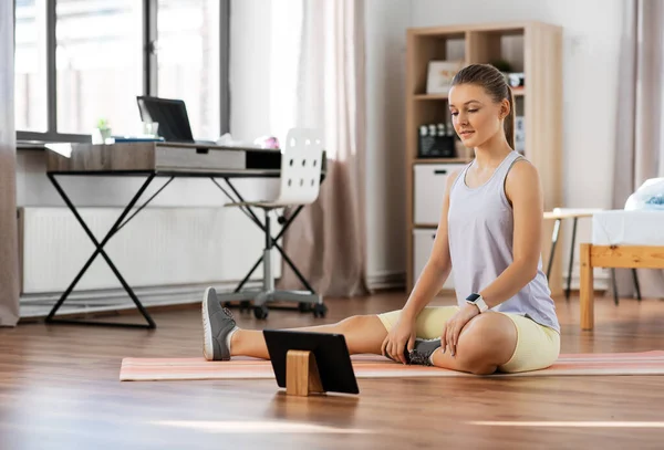 Tiener meisje met tablet pc oefenen thuis — Stockfoto