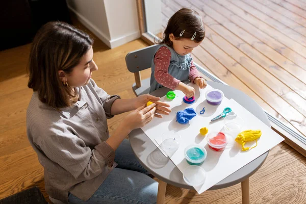 Mother and daughter playing with modeling clay — Foto Stock