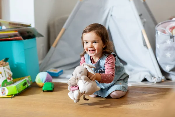 Niña feliz jugando con juguetes suaves en casa —  Fotos de Stock