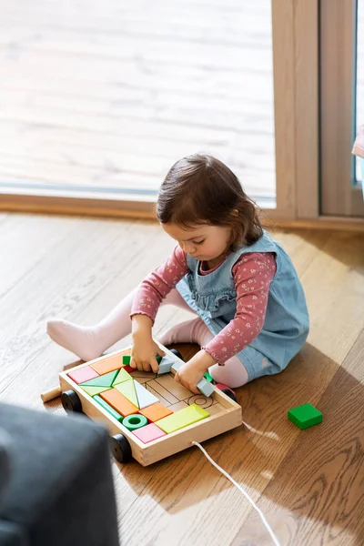 Menina feliz brincando com blocos de brinquedo em casa — Fotografia de Stock